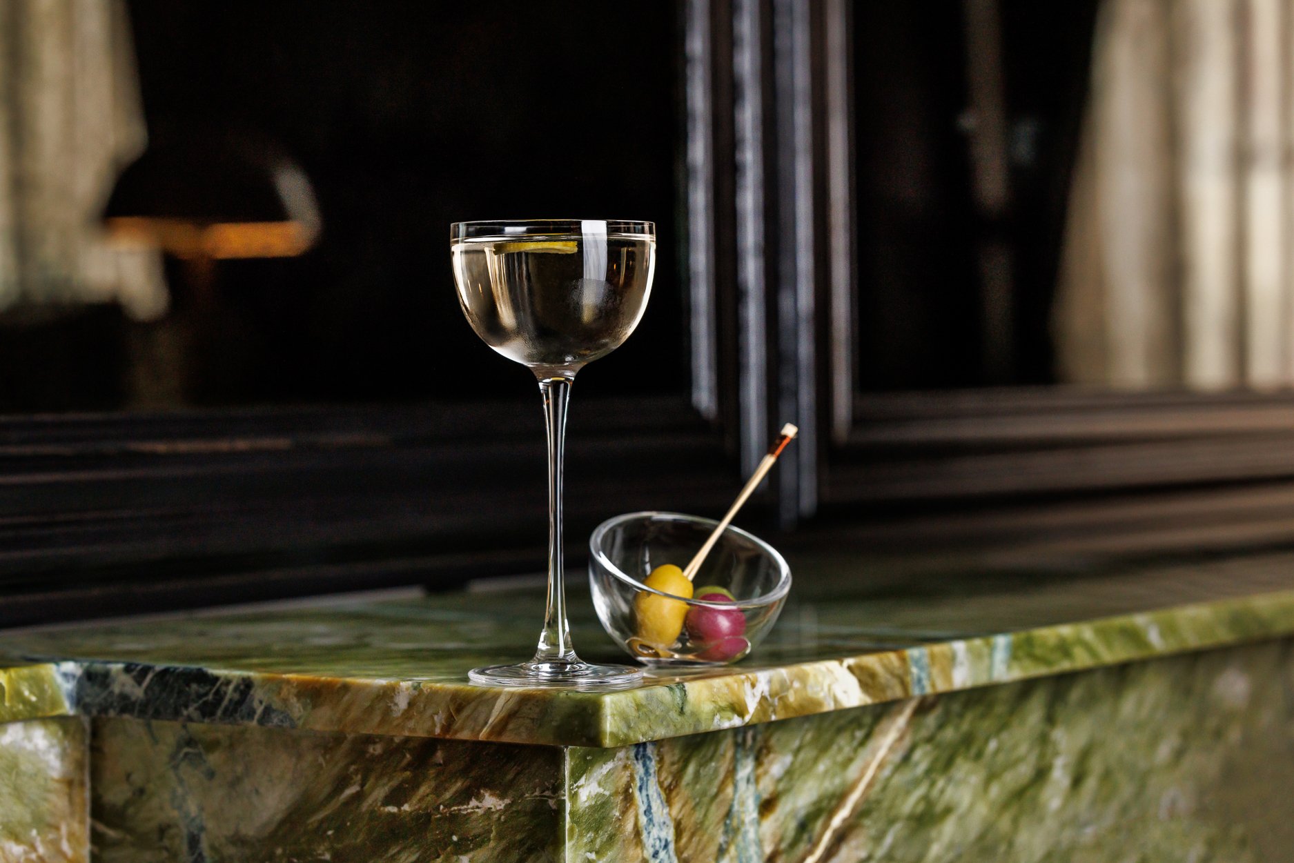 A clear cocktail in a glass with a tall stem.