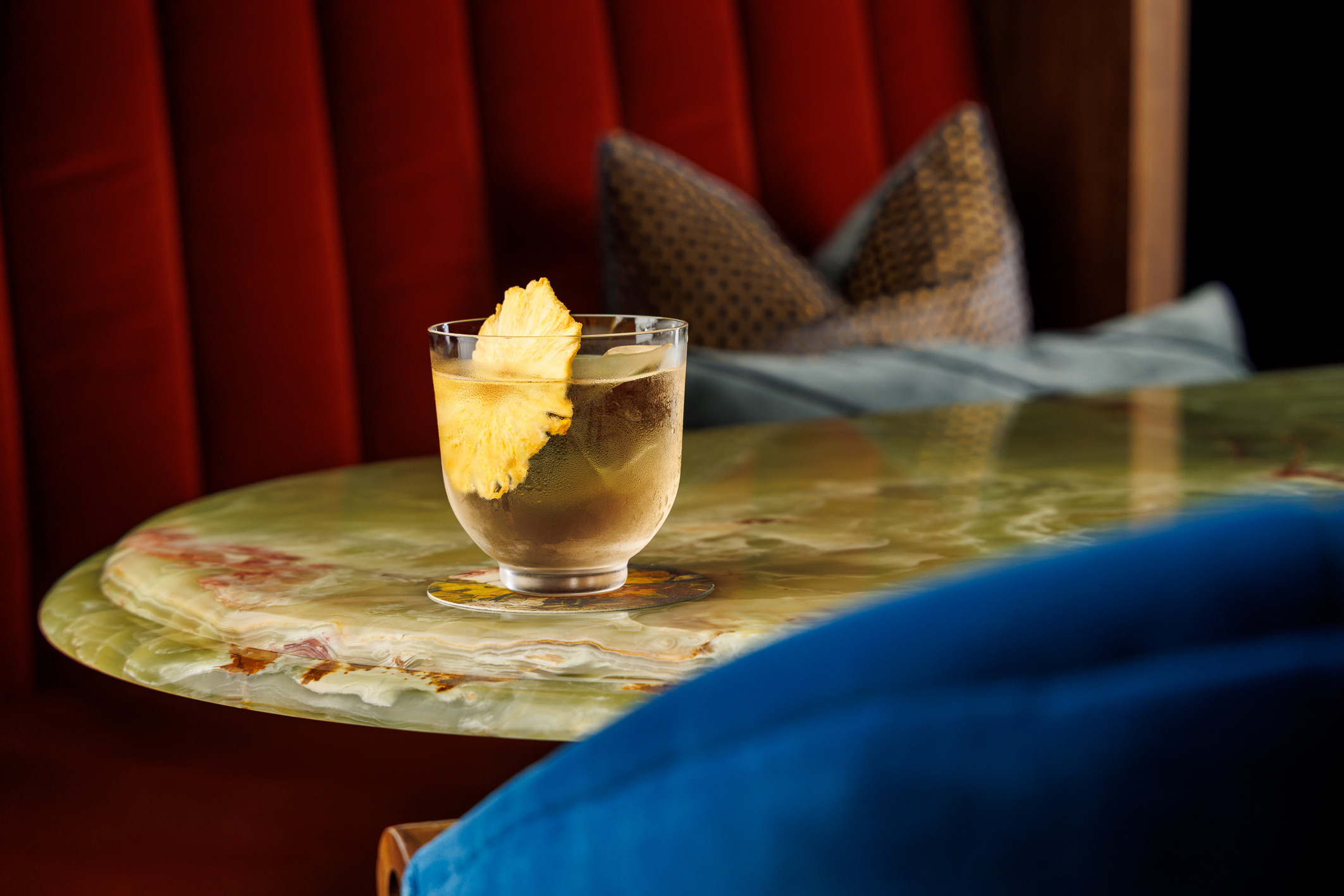 A cold cocktail with a dried pineapple slice garnish.