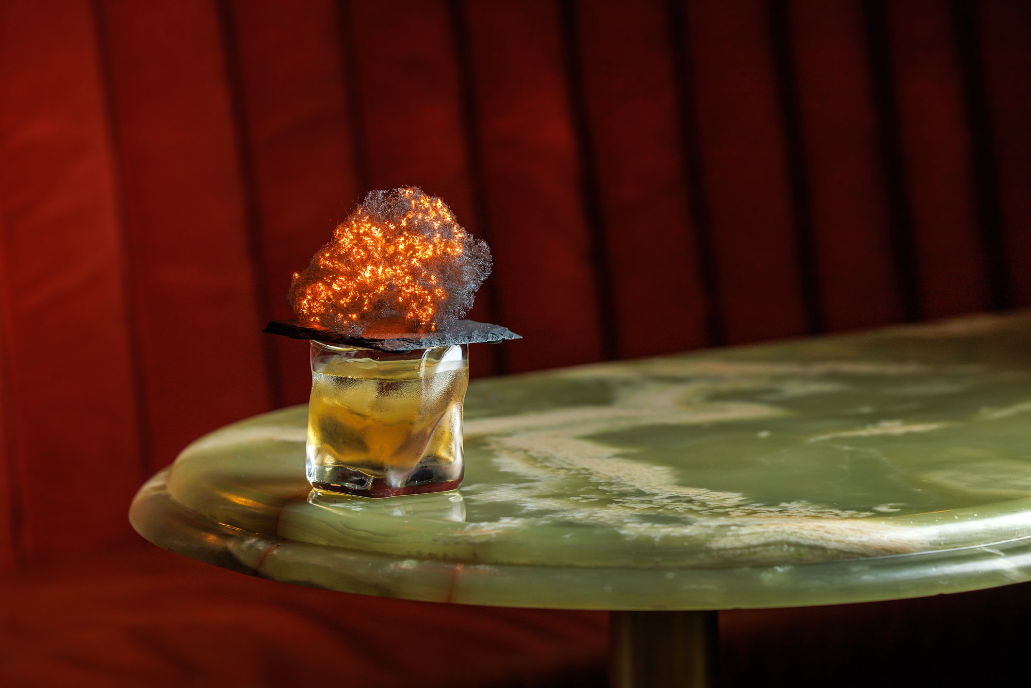 The Fairmont Library Bar's Sacred Beast cocktail with fiery steel wool garnish.