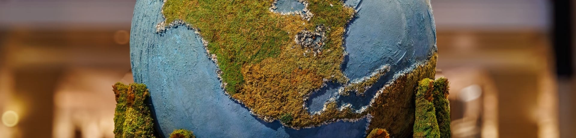 An art installation in the lobby of Royal York of mossy green hands holding up a globe