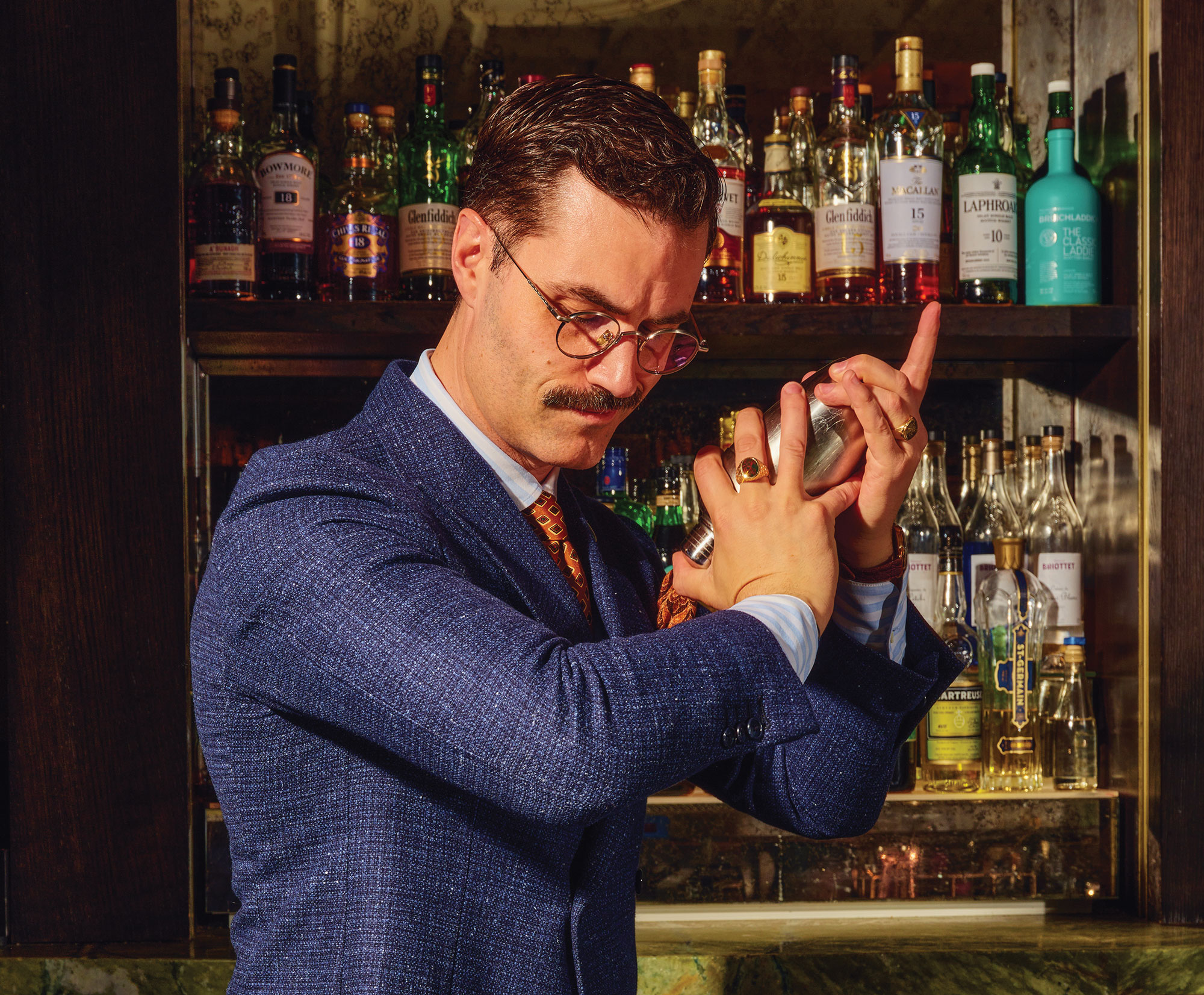 A bartender shaking a martini mixer.