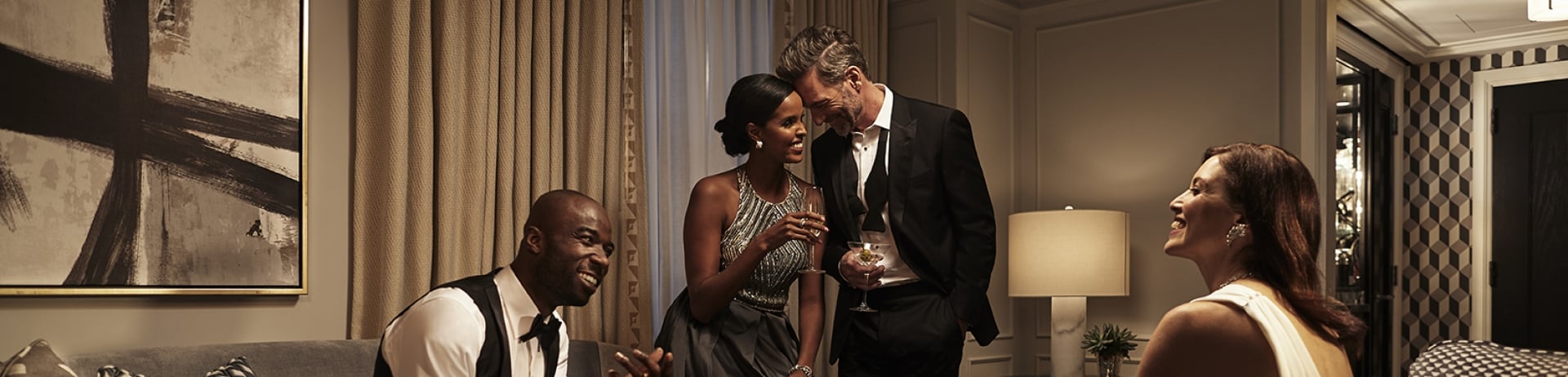 Guests in formal wear enjoying the living room space of a Fairmont Royal York suite.