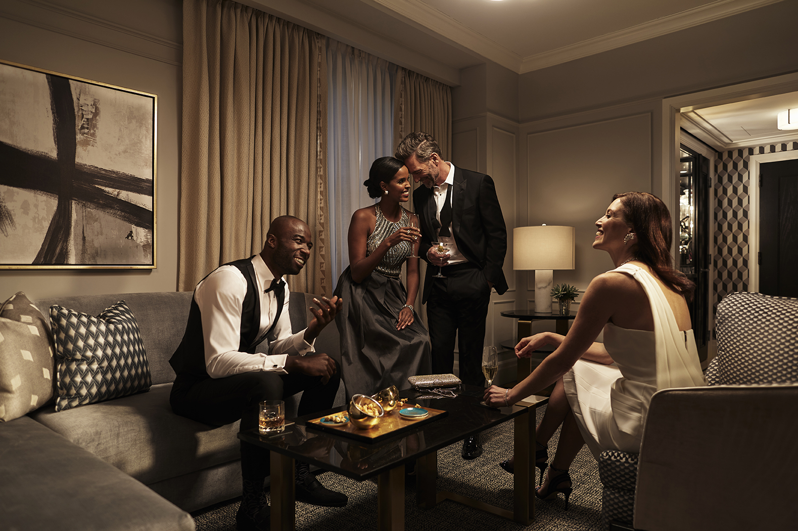 Guests in formal wear enjoying the living room space of a Fairmont Royal York suite.