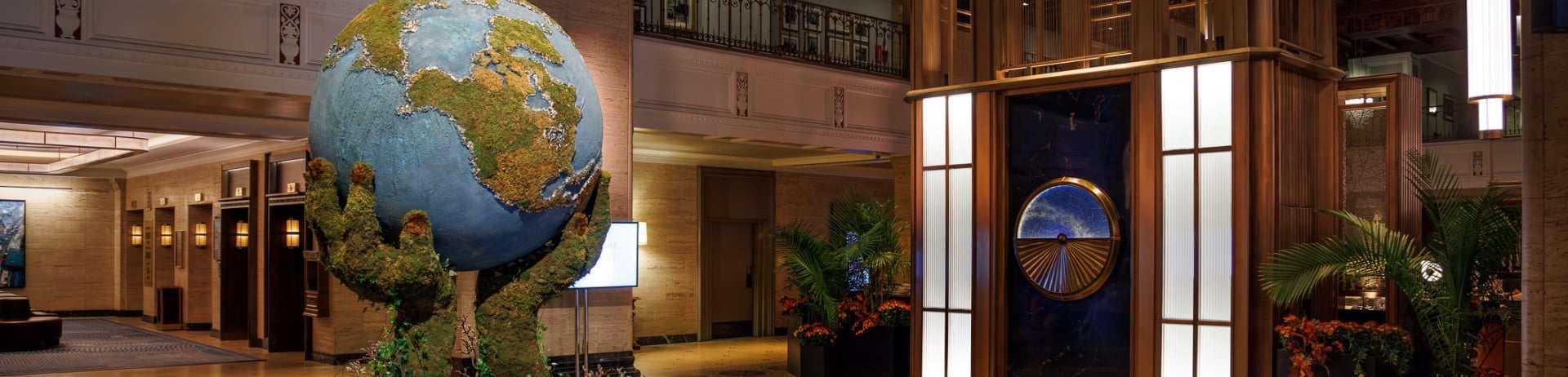 An art installation in the lobby of Royal York of green hands holding up a globe